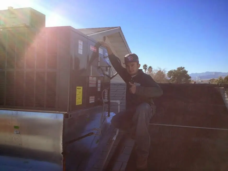 HVAC technician performing AC Tune-Up on a rooftop unit in Chatham